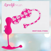 The OhMiBod Lovelife Krush Smart Kegel Fitness in pink is shown before its white box, adorned with pink and white heart patterns and “SMART KEGEL FITNESS”—a stylish pelvic floor fitness device from OhMiBod.